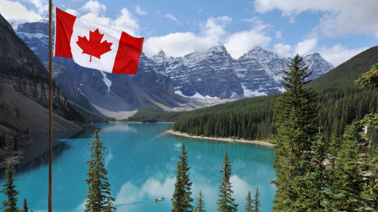 The Canadian National flag set against the Rocky Mountains of Banff National ParkCanada