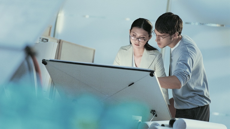 Woman and man with drawing board