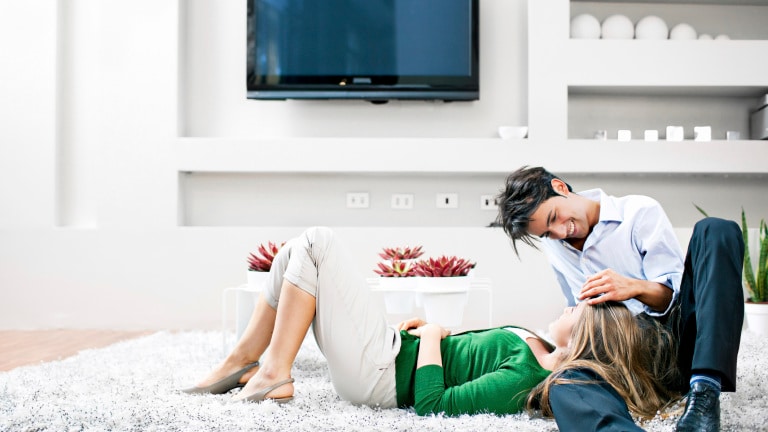 Couple in living room lying on the floor on a carpet