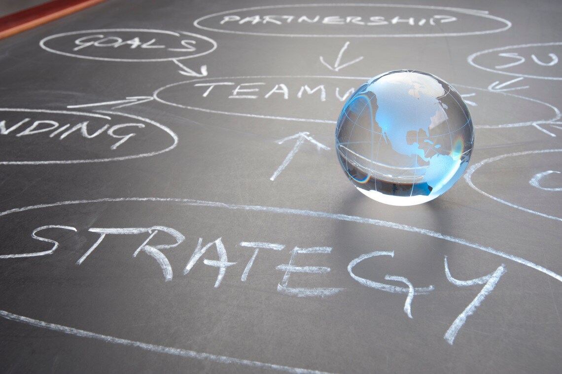 Flowchart on a chalk board with world globe showing America