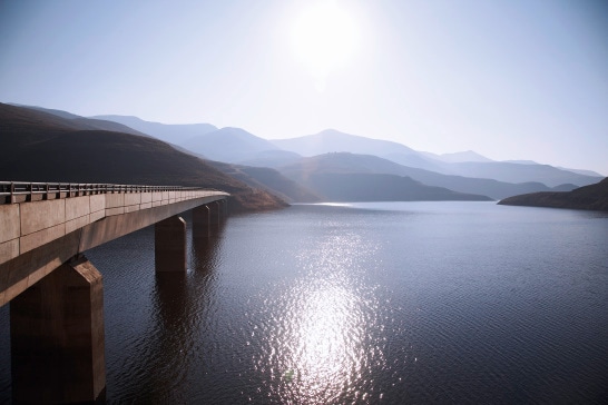 Sea View of bridge going over Katse Dam with sun reflecting off water